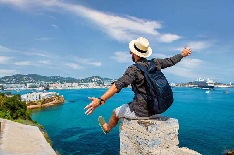 Guy sitting on a stone by the beach
